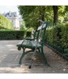 Canne de marche réglable en aluminium avec une poignée en derby, posée sur un banc en bois dans un jardin public ensoleillé.