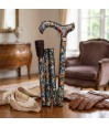 Canne de marche pliante avec motif floral coloré posée sur une table en bois.