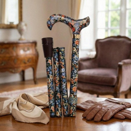 Canne de marche pliante avec motif floral coloré posée sur une table en bois.
