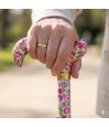 Femme senior tenant la poignée Derby de la canne fleurie pendant une marche élégante et colorée.
