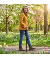 Femme de 50 ans marchant au jardin avec une canne ergonomique tenue de la main droit.