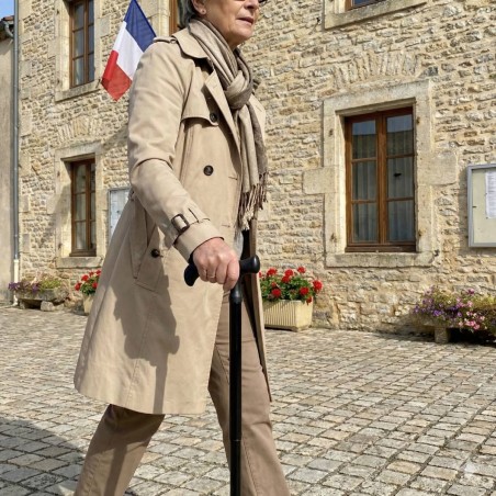 Femme senior montrant sa canne de marche élégante et confortable, noire.