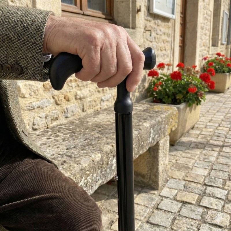 Homme senior avec une canne de marche noire de pharmacie, en poignée soft touch, classique et robuste.
