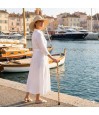 Femme senior au port avec sa canne de marche pliable fantaisie et sa poignée derby originale.