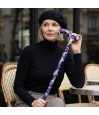 Femme élégante au café tenant subtilement sa canne de marche féminine et remboursable.