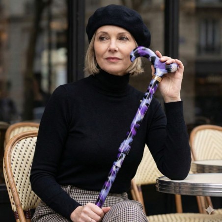 Femme élégante au café tenant subtilement sa canne de marche féminine et remboursable.