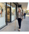 Femme 50 ans chic présentant sa canne de marche motif tournesols, pièce d'art subtile et très élégante.