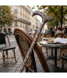 Canne de marche fantaisie arc-en-ciel originale avec poignée derby sur une chaise à Paris.