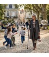 Femme senior souriante marchant avec sa canne de marche près de jolies bulles de savon.