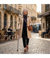 Femme élégante marchant dans la rue avec sa canne de marche originale et élégante.