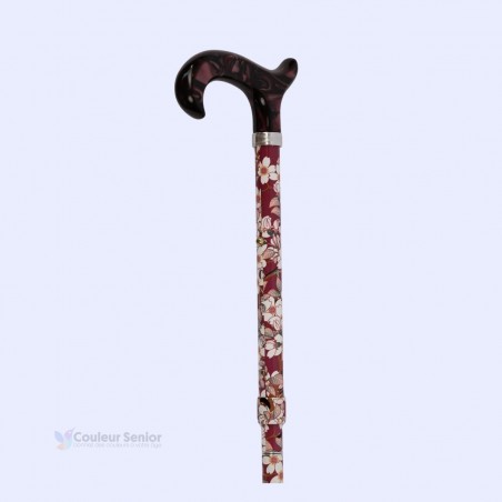 Poignée Derby en plexiglas sur canne de marche pour femme luxe vieux rose à fleurs blanches.