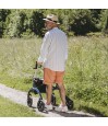 Senior dans un jardin de terre, prouvant que ce rollator en carbone est robuste et stable.
