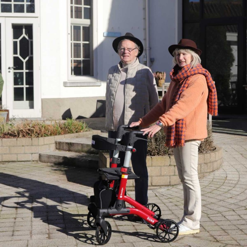 Senior se promenant en extérieur avec le déambulateur Brooklyn rouge Quun, maniable et léger.