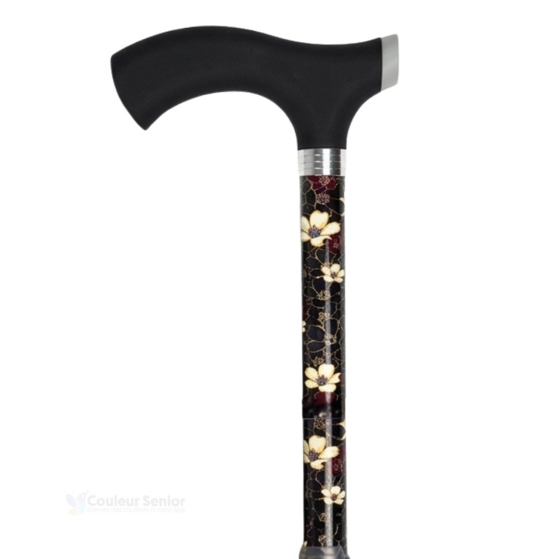 Canne de marche noire avec des fleurs blanches et une poignée douce au toucher. Éligible au remboursement par la Sécu.