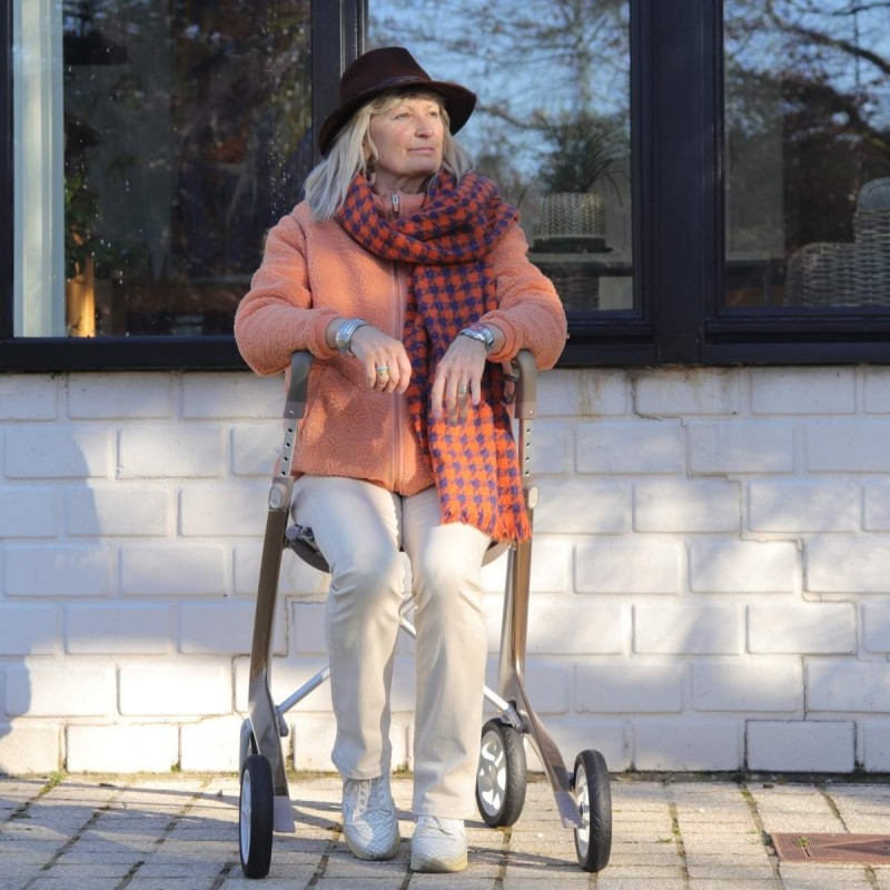 Femme assise sur déambulateur 4 roues Carbon Ultralight ACRE or champagne