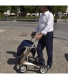 Homme senior qui se déplace avec son déambulateur 4 roues Carbon Ultralight ACRE or champagne