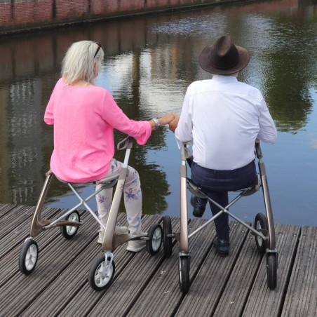 Couple de personnes âgées assis avec leur déambulateur 4 roues Carbon Ultralight ACRE or champagne