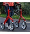 Femme senior marchant avec zoom sur poignées et cadre aluminium du déambulateur 4 roues Let's Fly Trust rouge