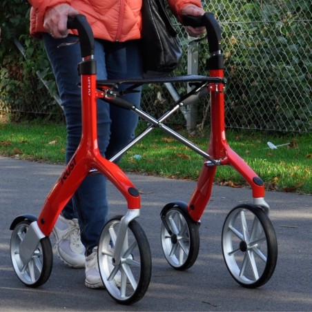 Femme senior marchant avec zoom sur poignées et cadre aluminium du déambulateur 4 roues Let's Fly Trust rouge