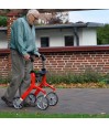 Senior homme marchant avec déambulateur 4 roues Let's Fly Trust rouge