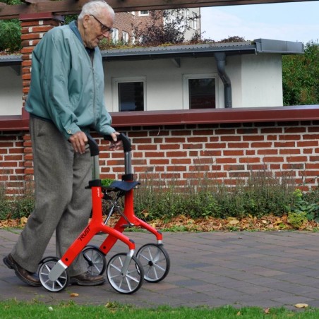 Senior homme marchant avec déambulateur 4 roues Let's Fly Trust rouge