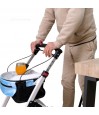 Senior tenant déambulateur Neo Indoor blanc, avec un plateau de desserte et un verre de jus posé dessus.