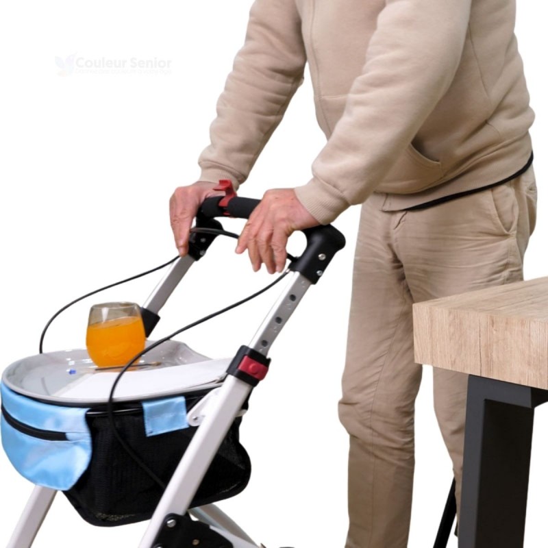 Senior tenant déambulateur Neo Indoor blanc, avec un plateau de desserte et un verre de jus posé dessus.