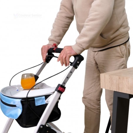 Senior tenant déambulateur Neo Indoor blanc, avec un plateau de desserte et un verre de jus posé dessus.