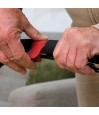 Gros plan sur les mains d’un senior actionnant le frein rouge ergonomique du déambulateur Neo Indoor blanc. Rollator pratique.