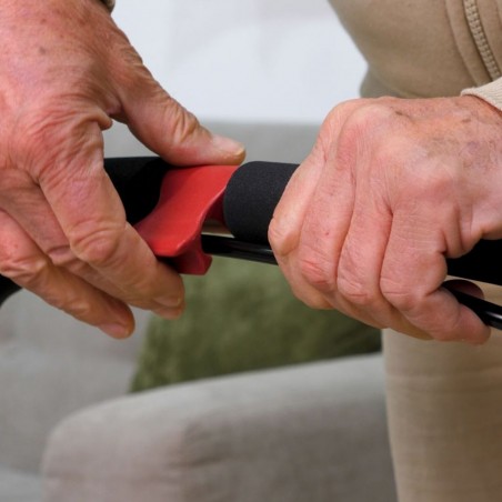 Gros plan sur les mains d’un senior actionnant le frein rouge ergonomique du déambulateur Neo Indoor blanc. Rollator pratique.
