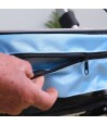 Senior ouvrant la fermeture éclair du sac bleu amovible du déambulateur Neo Indoor. Pratique pour l’intérieur de l’appartement.