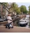 Dame senior assise sur rollator Rollz Flex blanc sur un pont face aux canaux d'Amsterdam