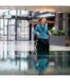 Senior souriante assise sur siège intégré du rollator Rollz Flex blanc dans un centre commercial