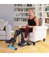 Femme senior utilisant le pédalier elliptique compact HomeTrack assise dans un fauteuil pour la rééducation des jambes