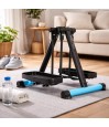 Pédalier elliptique compact HomeTrack posé sur un tapis de salon avec bouteille d'eau et serviette