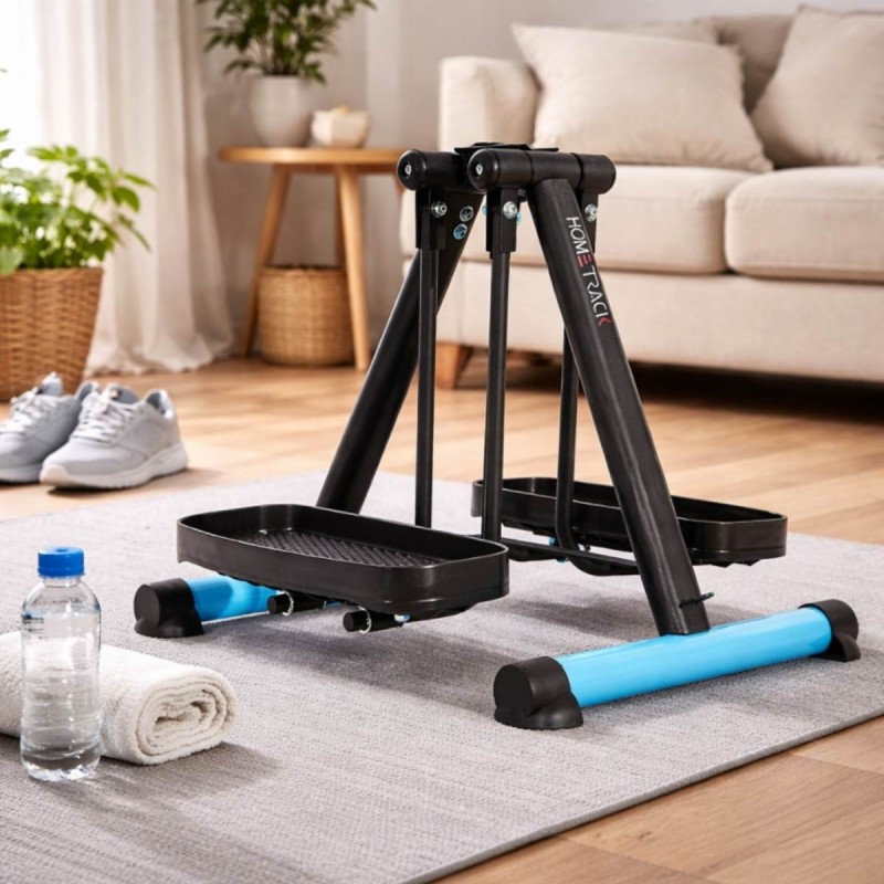 Pédalier elliptique compact HomeTrack posé sur un tapis de salon avec bouteille d'eau et serviette