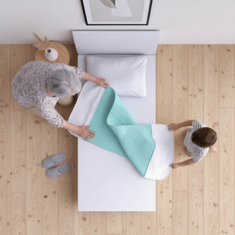 Grand-mère et enfant installant une alèse lavable turquoise sur un lit simple