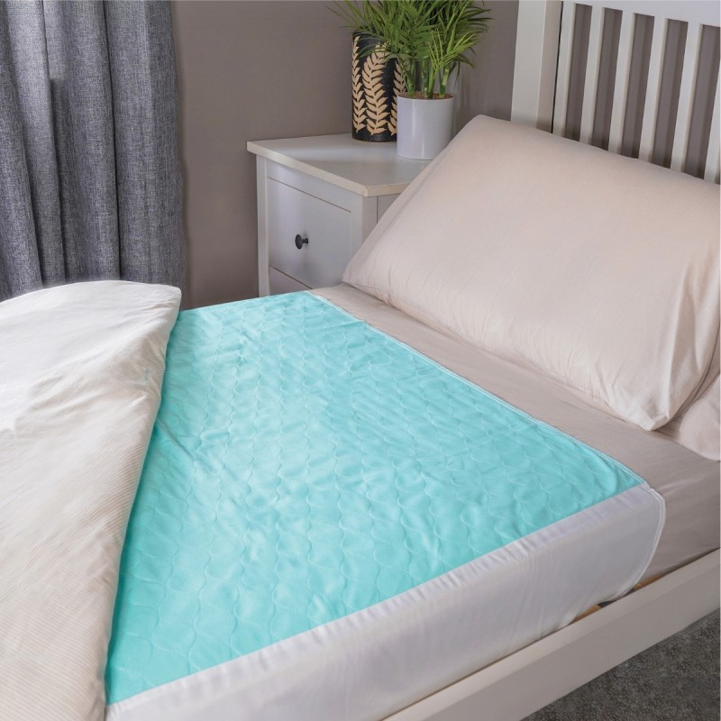 Alèse imperméable lavable turquoise posée sur lit simple – protection incontinence