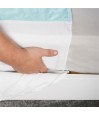 Gros plan installation du rabat de l'alèse lavable sous le matelas lit double – maintien sécurisé
