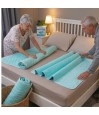 Couple senior installant une alèse lavable avec rabats sur lit double – protection incontinence nuit