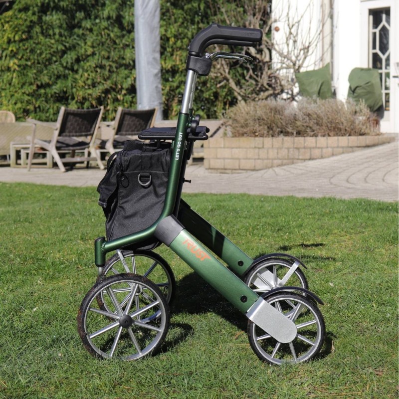 Déambulateur Let's Go Out vert avec sac noir inclus vue de côté en extérieur jardin