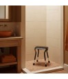 Siège douche confortable et pratique positionné dans douche carrelage beige salle de bain chaleureuse