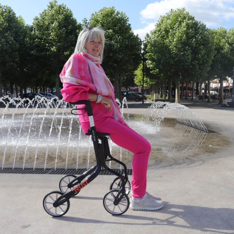 Dame senior souriante assise sur déambulateur lets move noir fontaine ville sécurité confort