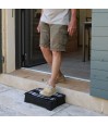 Senior sortant de la maison sans effort grâce au marchepied, protégeant efficacement les genoux.
