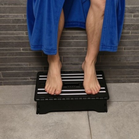 Senior sortant de la douche en toute sérénité, avec un appui stable, grâce au marchepied pliable noir.