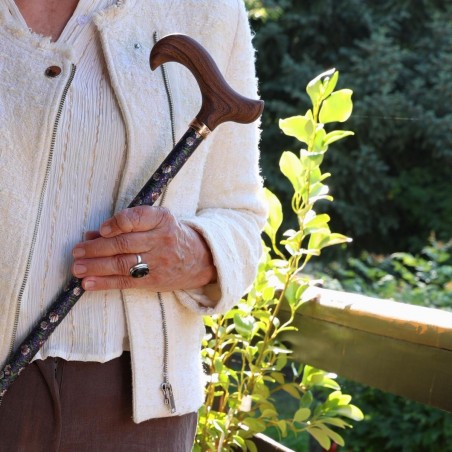 Madame, utilisant la canne de marche réglable Lotus de Nuit, vêtue d’une tenue blanche et marron, très élégante, prête à sortir.