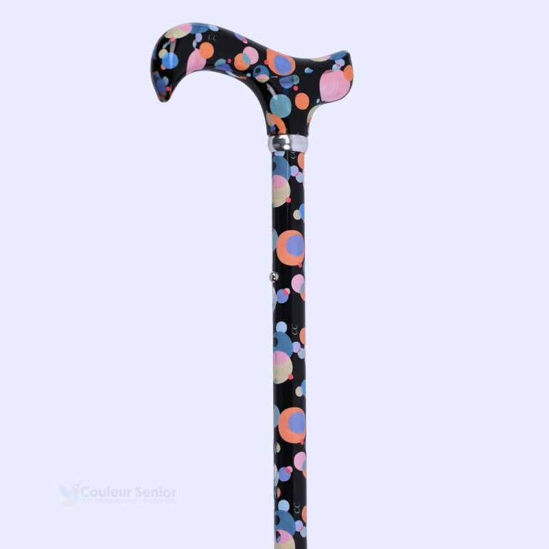 Poignée Derby d'une canne de marche noire fantaisie ornée de cercles orangés et blancs.