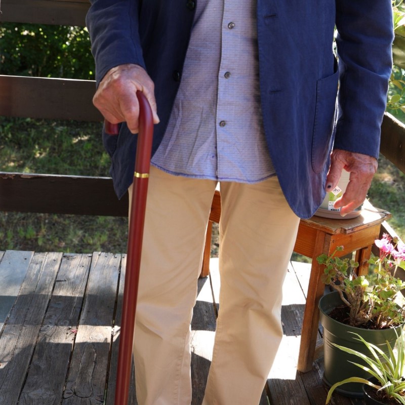 Homme senior marchant en ville. Sa canne classique offre prestance et sécurité au quotidien.