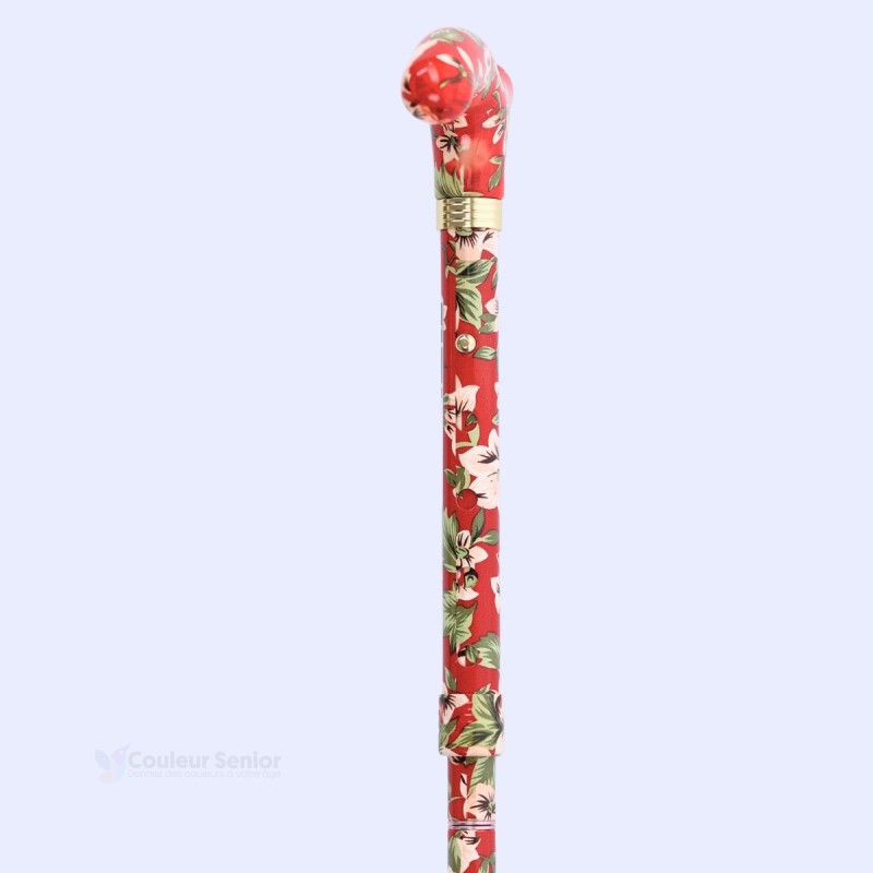 Mise en situation de la canne fleurs blanches sur fond rouge. Accessoire pratique au quotidien.