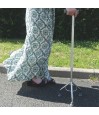 Femme utilisant la canne de marche tripode stable et sécurisante lors de ses déplacements quotidiens en extérieur